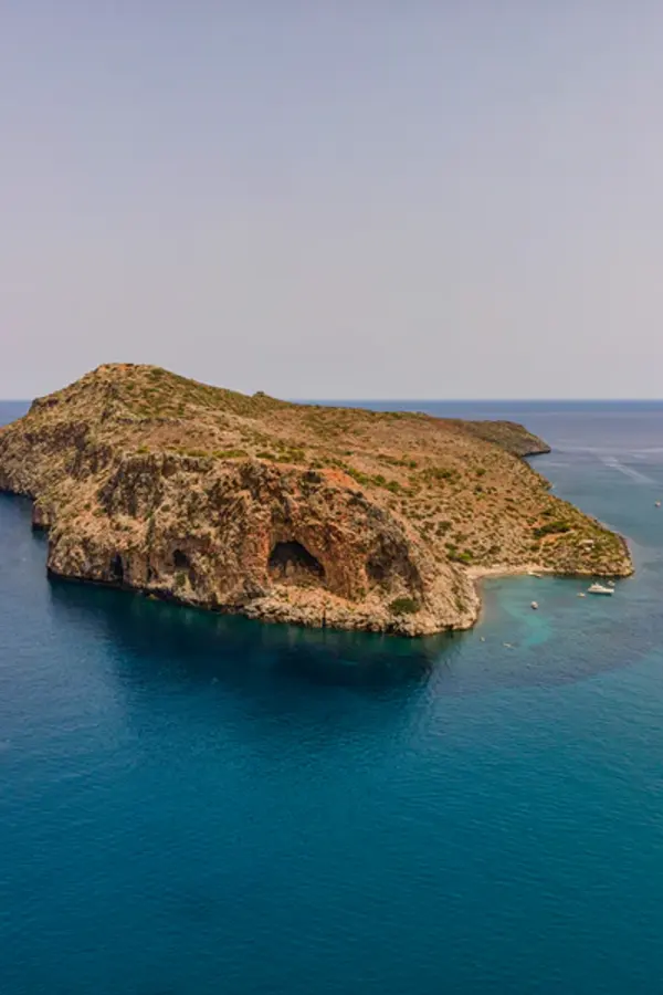 Panoramic view of the rugged coastline and crystal blue waters near Agii Theodorou, Crete.